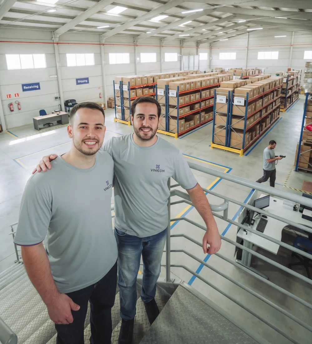 Time Vinicom dentro do centro de distribuição, com estruturas de armazenagem ao fundo