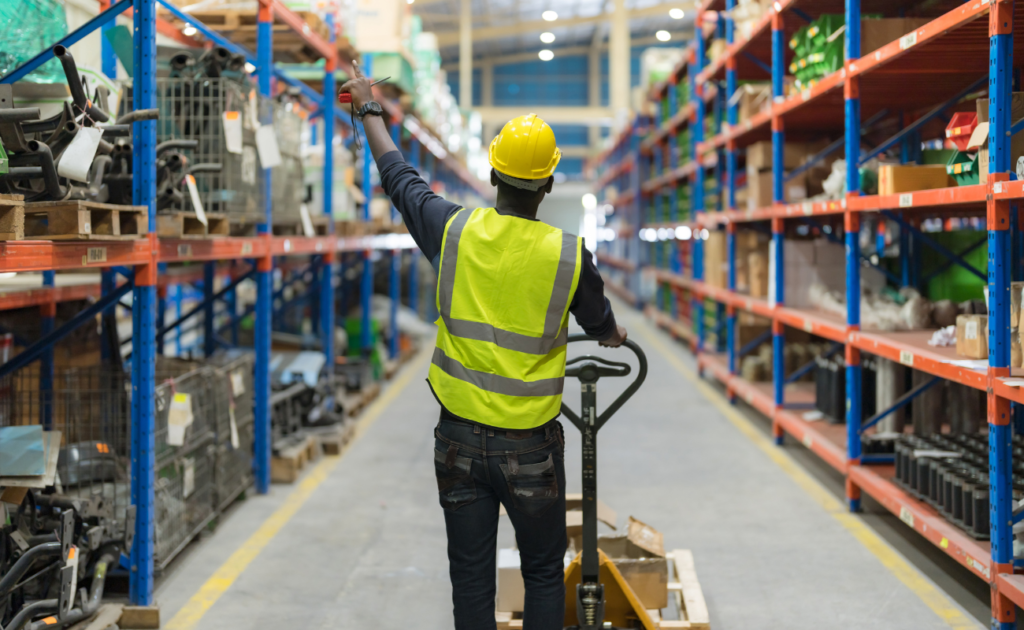 Homem dentro de um depósito analisando pedidos